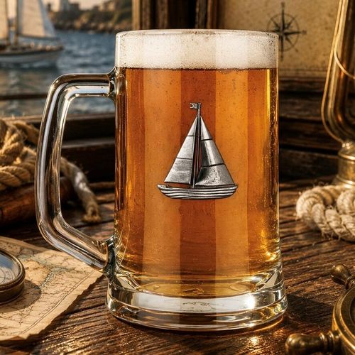A Beer Tankard with a Pewter Sailing badge on the front, filled with Amber Beer