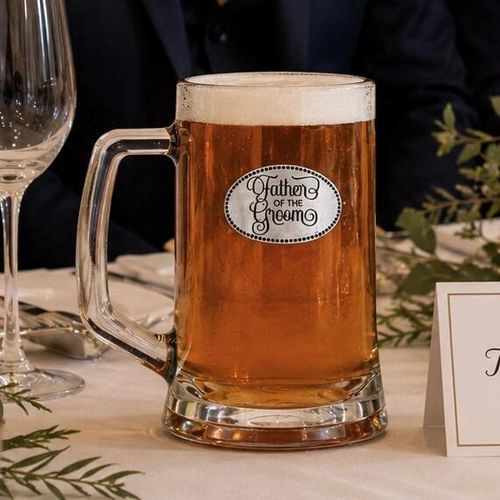 A Beer Tankard with a Pewter Father of the Groom badge on the front, filled with Amber Beer