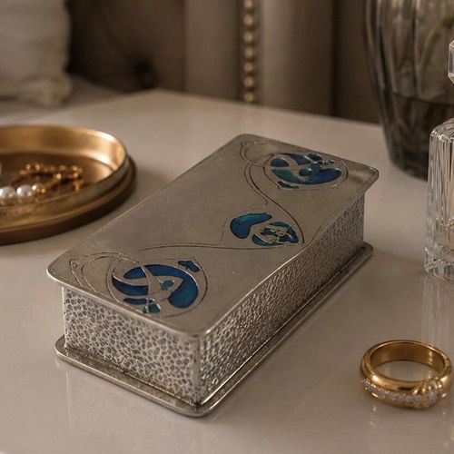 An Archibald Knox designed Arts and Crafts pewter box with blue enamel inserts