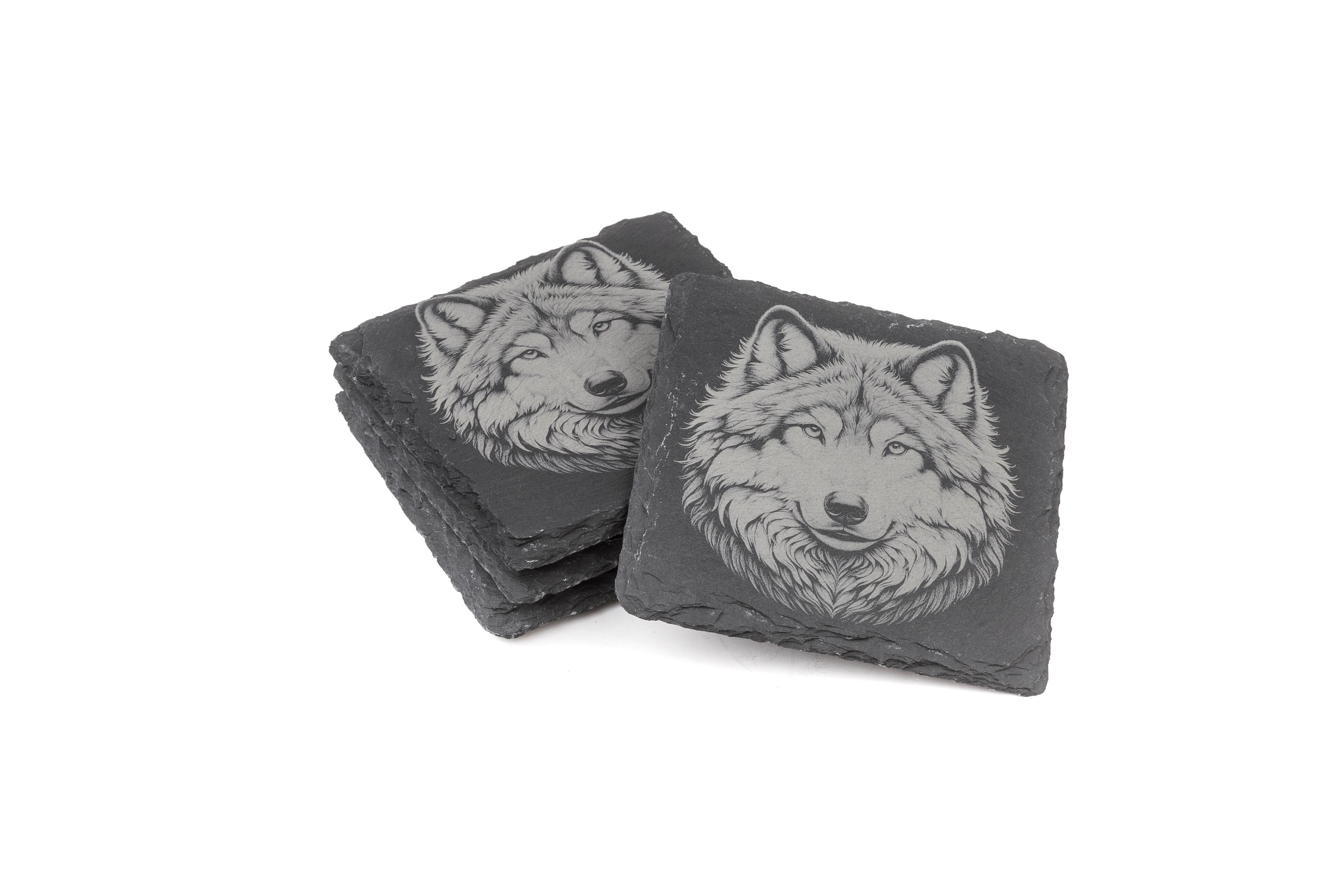 Two stacks of square slate coasters, each engraved with a detailed Wolf design.
