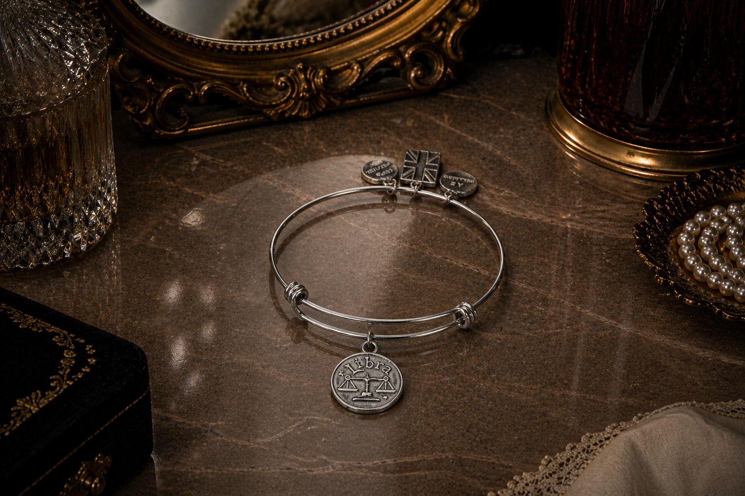 A Pewter charm bracelet showing a Libra Charm on a mantlepiece