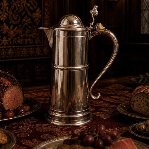 A tall, polished pewter Beefeater flagon with a hinged dome lid, a thumbpiece lever, and an elegant curved handle