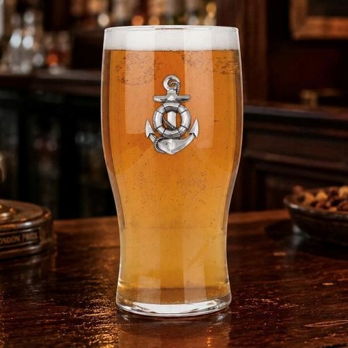 Pint glass with handmade pewter anchor and rope badge filled with golden beer