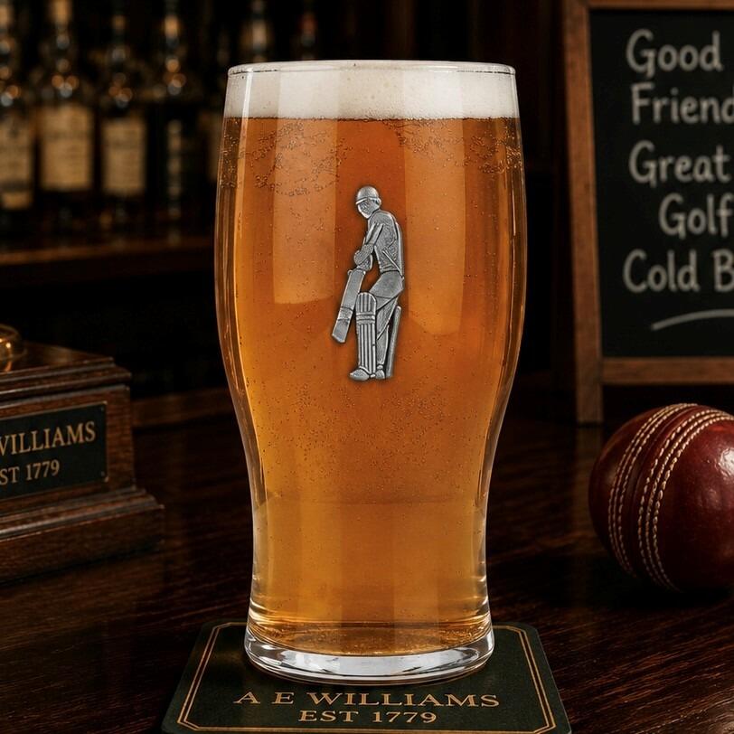 Pint glass with handmade pewter cricketer badge featuring batsman stance filled with golden beer