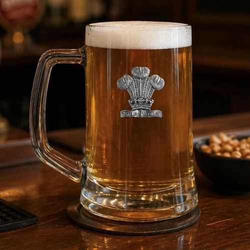 A Beer Tankard with a Pewter Welsh Feathers badge on the front, filled with Amber Beer