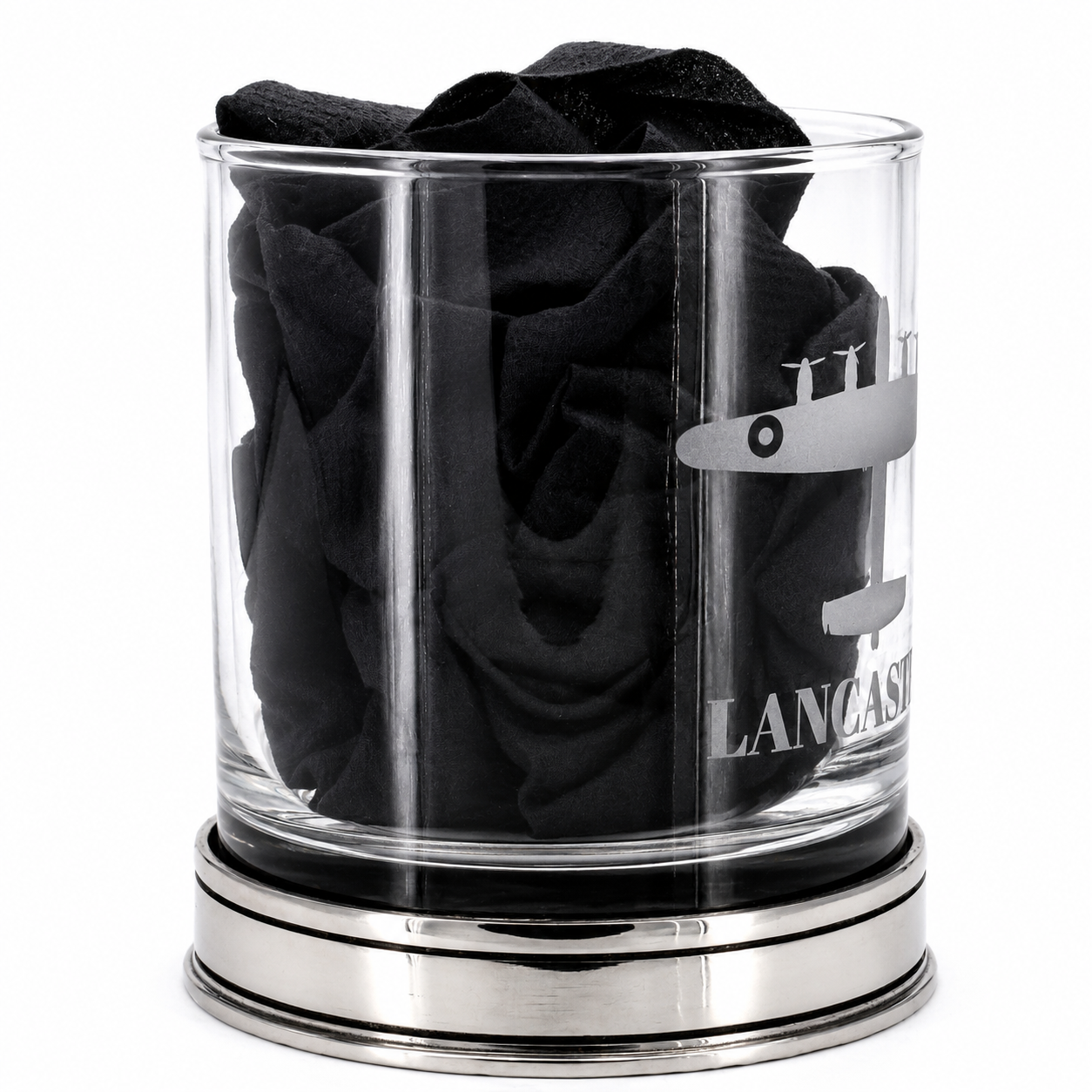 A whisky glass engraved with a lancaster bomber design with black tissue inside