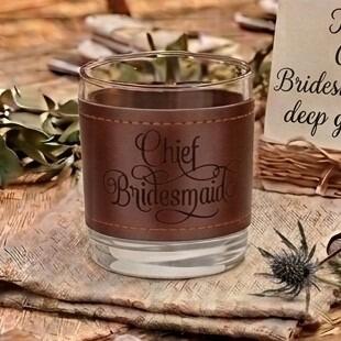 Glass tumbler wrapped in a brown stitched leather sleeve engraved with the words "Chief Bridesmaid" in elegant script