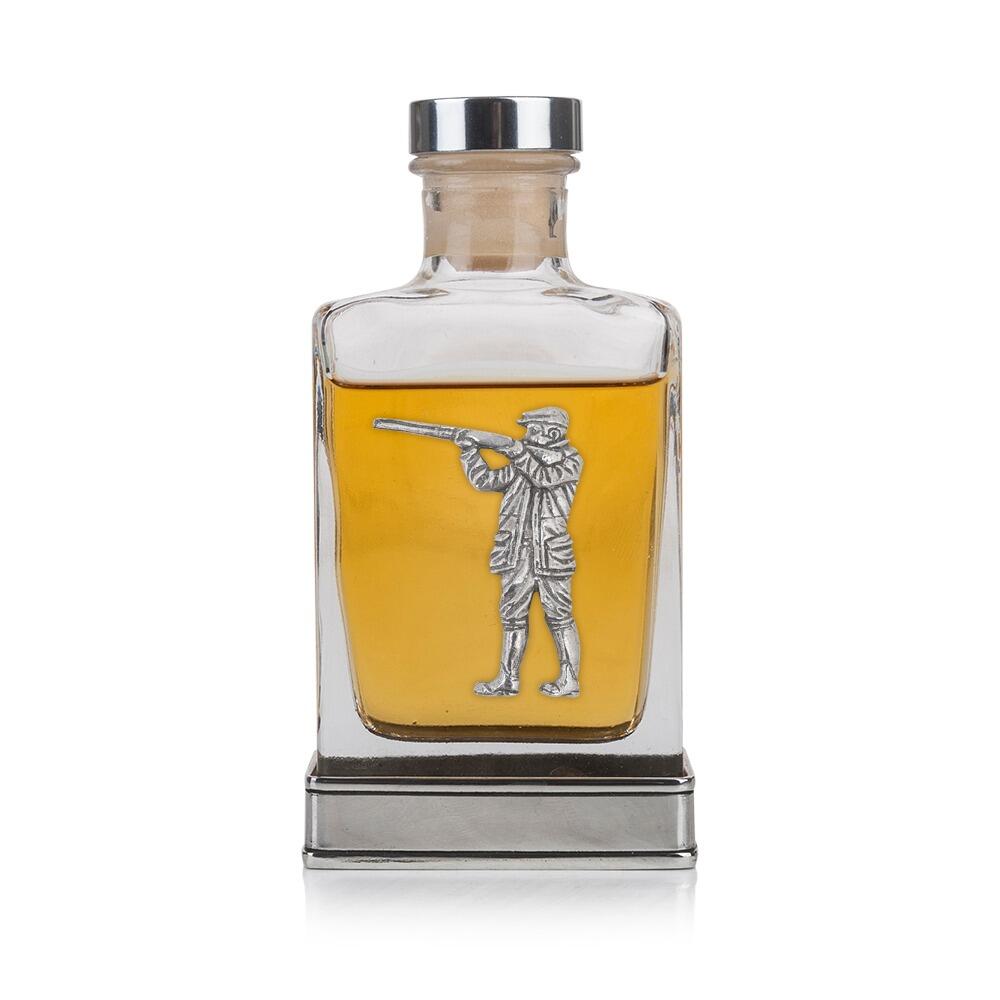 A glass flask with a pewter base and a handcrafted pewter shooting man emblem on the front