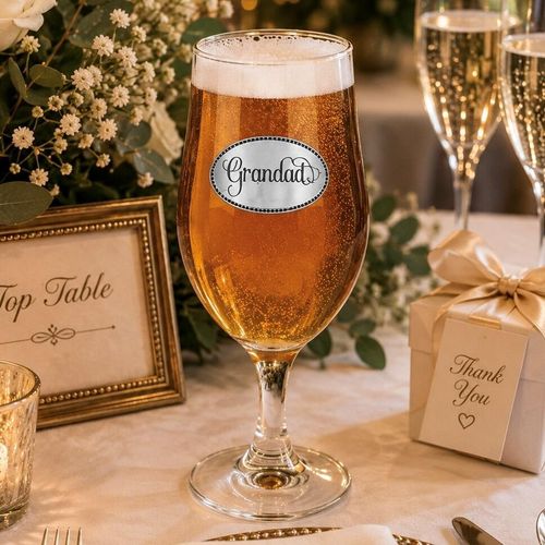 A Stemmed Pint Beer Glass with a Pewter Grandad badge on the front, filled with Beer