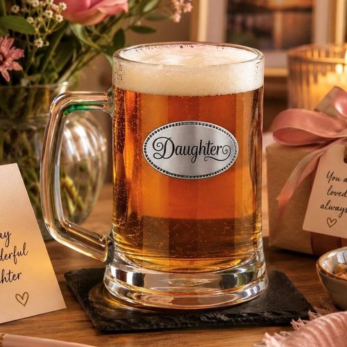 A Beer Tankard with a Pewter Daughter badge on the front, filled with Amber Beer