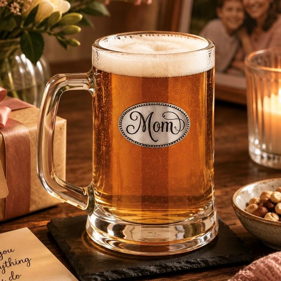 A Beer Tankard with a Pewter Mom badge on the front, filled with Amber Beer