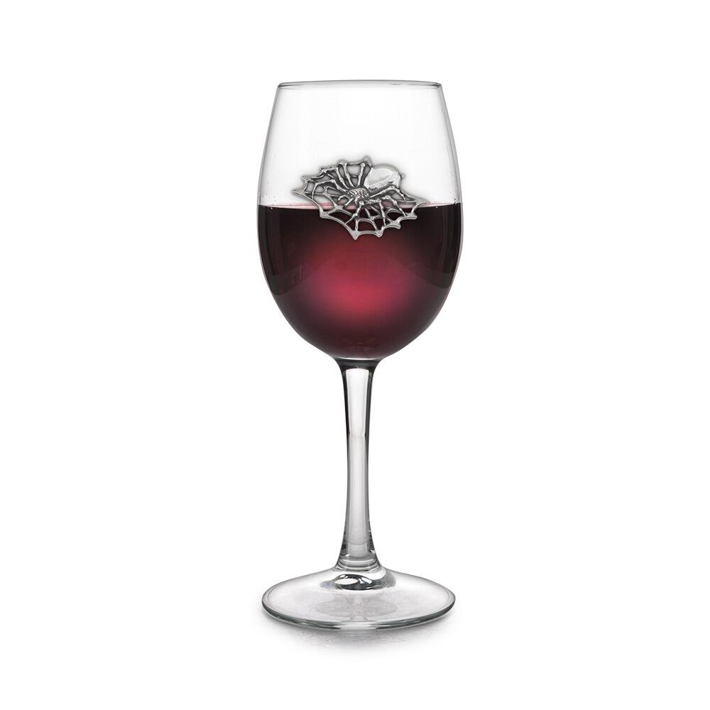 Wine glass with handmade pewter spider badge filled with red wine