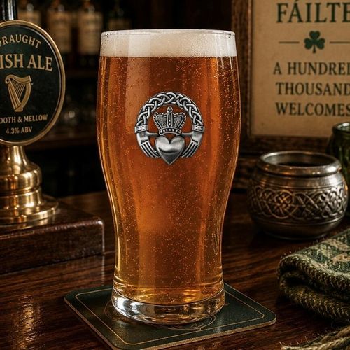 Pint glass with handmade pewter Irish Claddagh badge, filled with golden beer