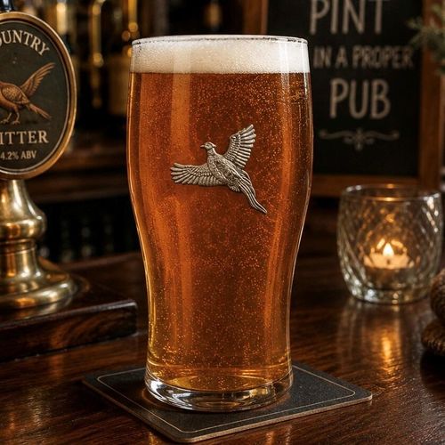 Pint glass with handmade pewter pheasant badge filled with golden beer