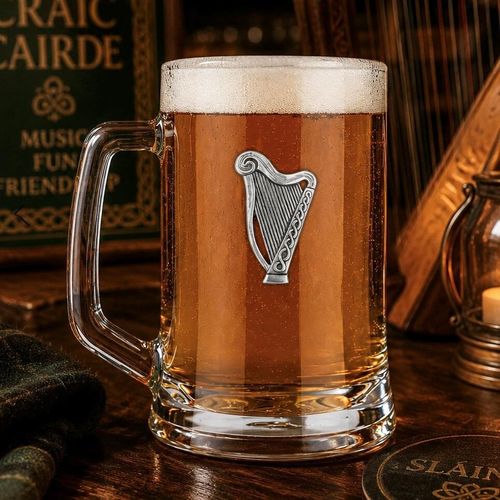 A Beer Tankard with a Pewter Harp badge on the front, filled with Amber Beer