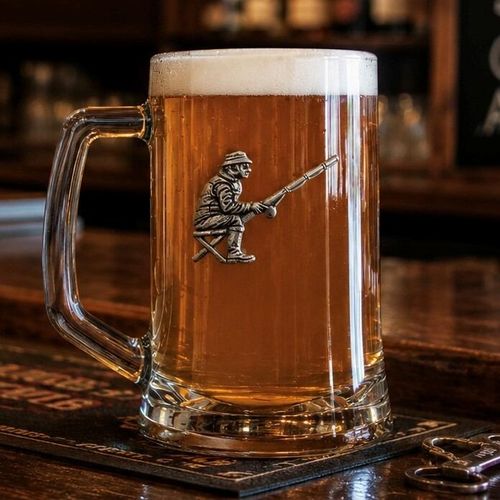 A Beer Tankard with a Pewter Fishing badge on the front, filled with Amber Beer