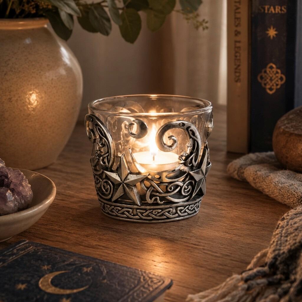 Pewter and glass tealight candle holder featuring an intricate celestial design with crescent moons, stars, and Celtic knotwork bands