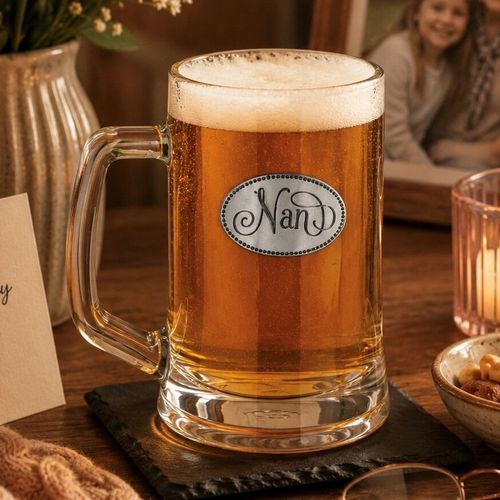 A Beer Tankard with a Pewter Nan badge on the front, filled with Amber Beer