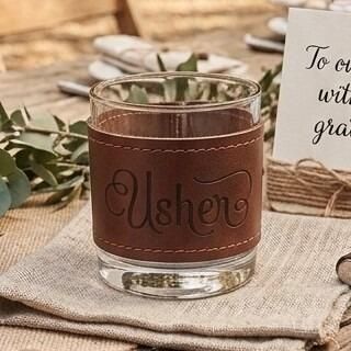 Glass tumbler wrapped in a brown stitched leather sleeve engraved with the word "Usher" in elegant script