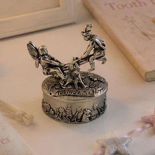 Round pewter tooth fairy box featuring a detailed sculpted lid with a fairy and an elf playing on a seesaw, decorated with a relief of woodland mushrooms and animals around the base