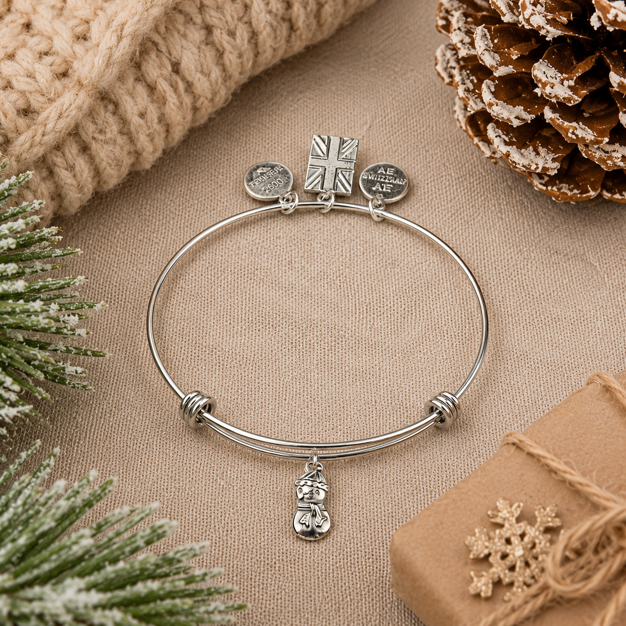 Pewter snowman charm expandable bracelet on festive Christmas background with pinecones and winter décor