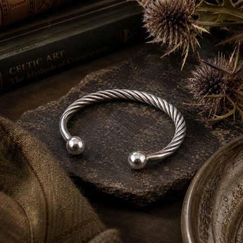 Twisted pewter torc bangle bracelet featuring polished ball terminals in a Celtic open-cuff style