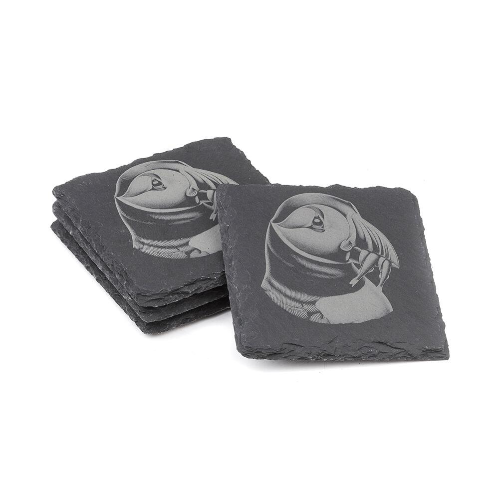 Two stacks of square slate coasters, each engraved with a detailed Puffin design.