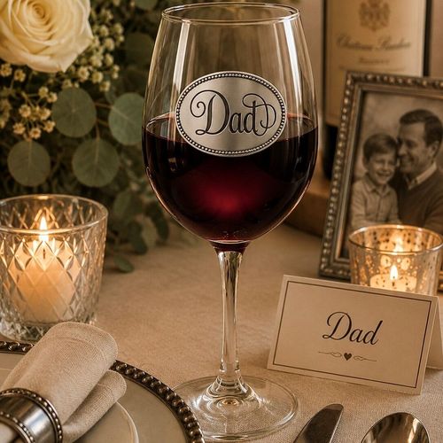Wine glass with handcrafted pewter Dad badge filled with red wine