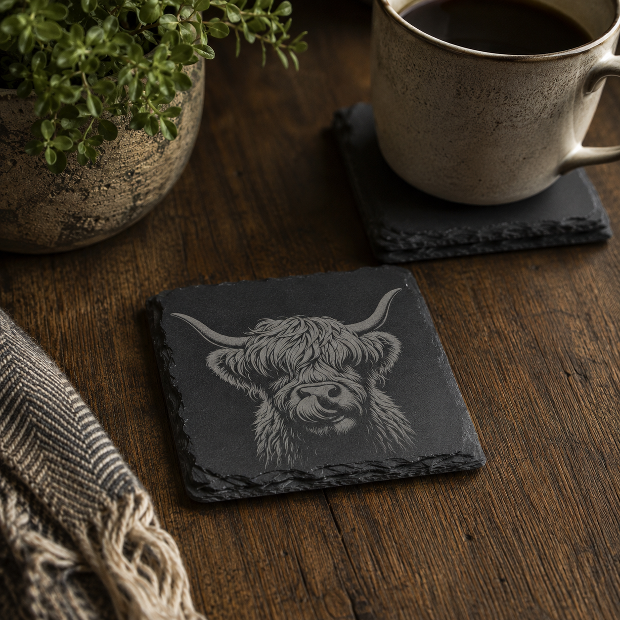Highland Cow Coasters in slate on a table, in a rustic charm environment