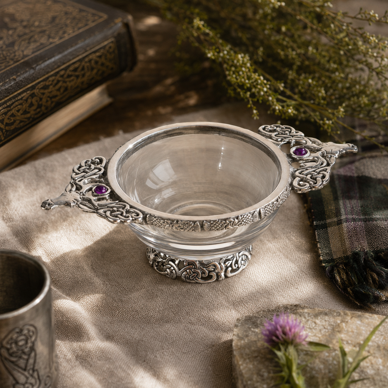 A Pewter and Glass Stag Quaich Bowl sitting on a table setting