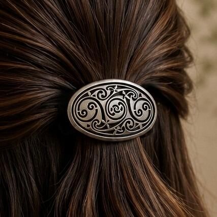 Oval pewter Celtic hair bobble featuring three intricate openwork triskele triskelion spirals within a smooth raised border