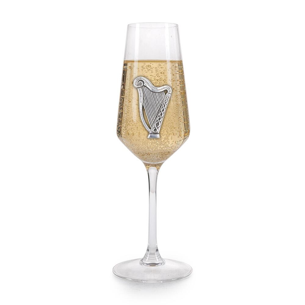 A Champagne Flute with a Pewter Harp badge on the front, filled with Champagne