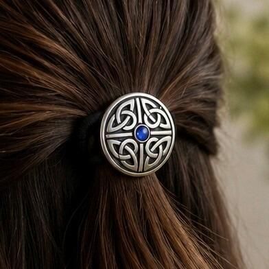 Circular pewter Celtic knotwork hair bobble featuring a small, round blue faux-sapphire gemstone in the center