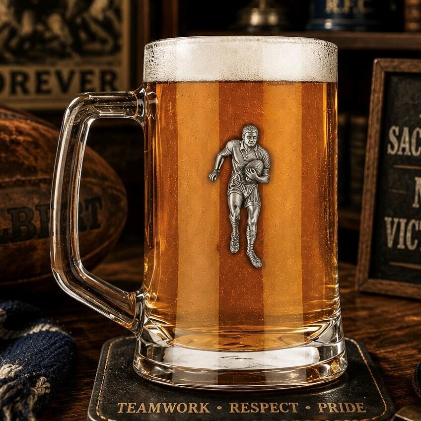 A Beer Tankard with a Pewter Rugby badge on the front, filled with Amber Beer