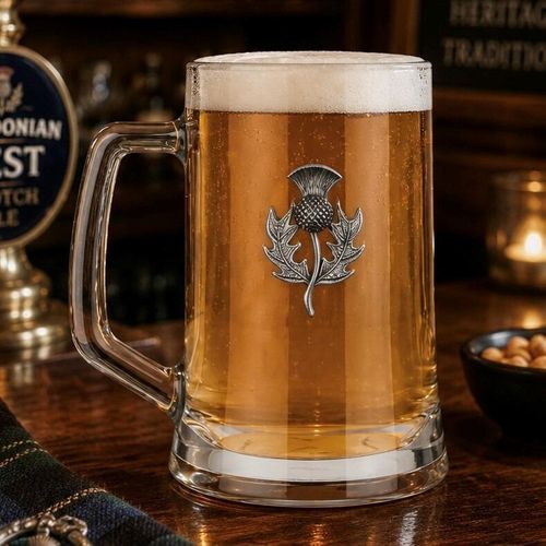 A Beer Tankard with a Pewter Thistle badge on the front, filled with Amber Beer
