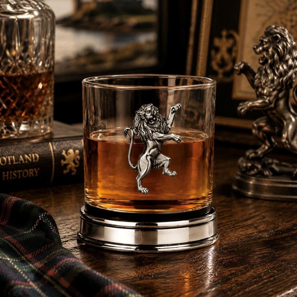 Whisky tumbler with pewter Rampant Lion emblem and polished base, partially filled with amber liquid