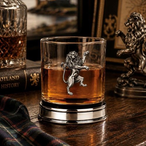 Whisky tumbler with pewter Rampant Lion emblem and polished base, partially filled with amber liquid