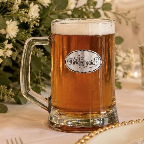 A Beer Tankard with a Pewter Bridesmaid badge on the front, filled with Amber Beer