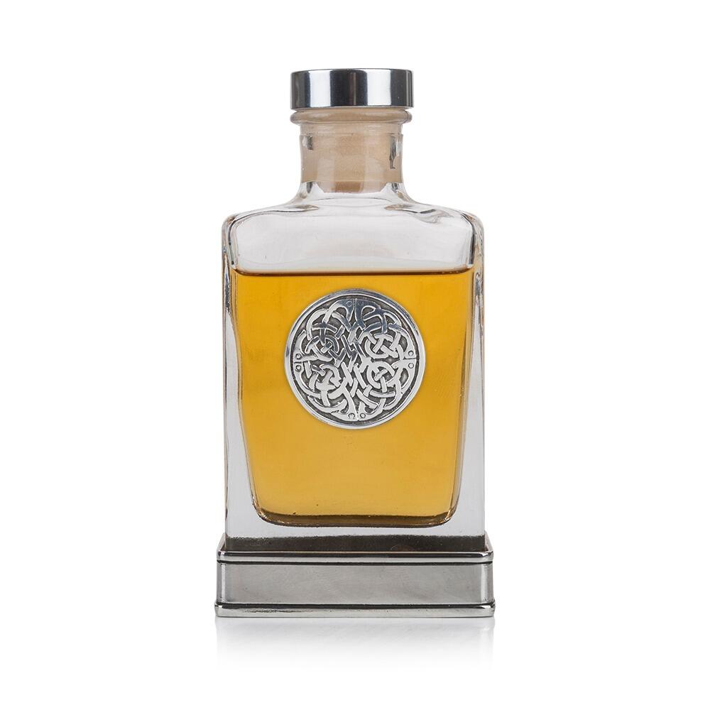 A glass flask with a pewter base and a handcrafted pewter Never Ending Knot emblem on the front