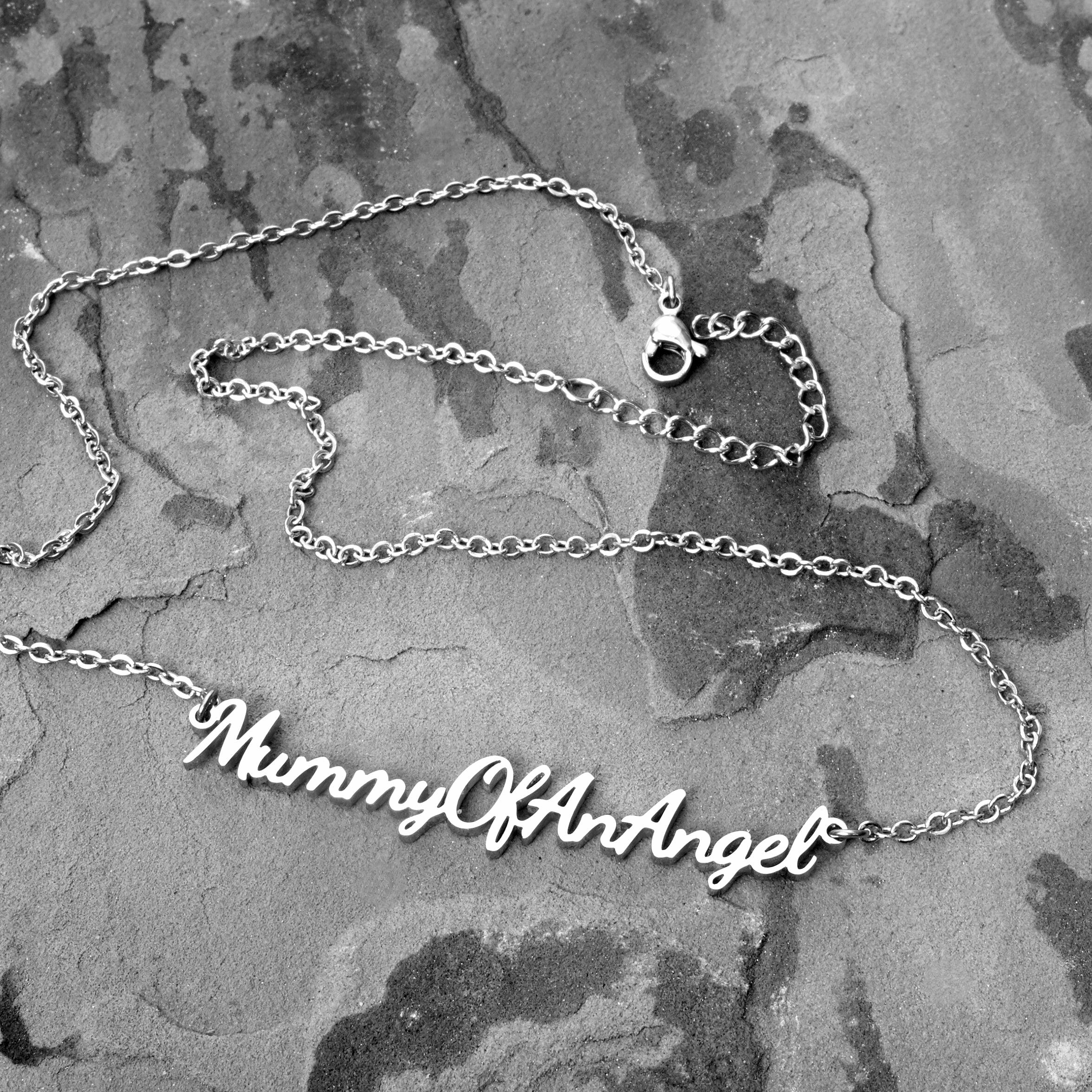 Mummy of an Angel necklace arranged on a textured surface with full chain visible and ‘Mummy of an Angel’ pendant