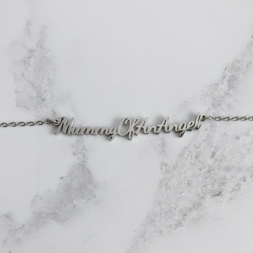 Close-up of Mummy of an Angel necklace on marble background showing ‘Mummy of an Angel’ engraving