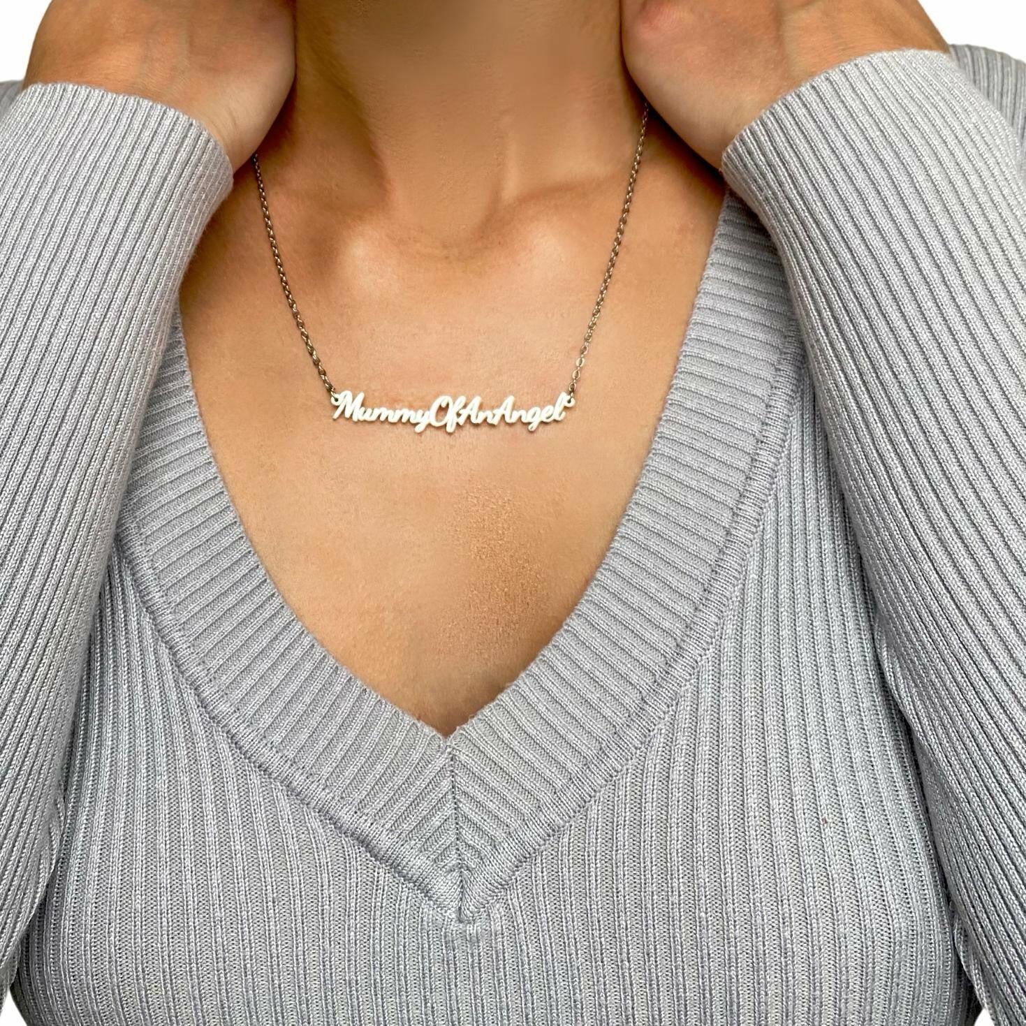 Person wearing Mummy of an Angel necklace styled with a V-neck top showing pendant position
