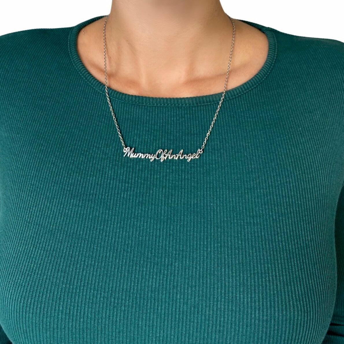Person wearing Mummy of an Angel necklace styled with a crew neck top showing chain length and pendant placement