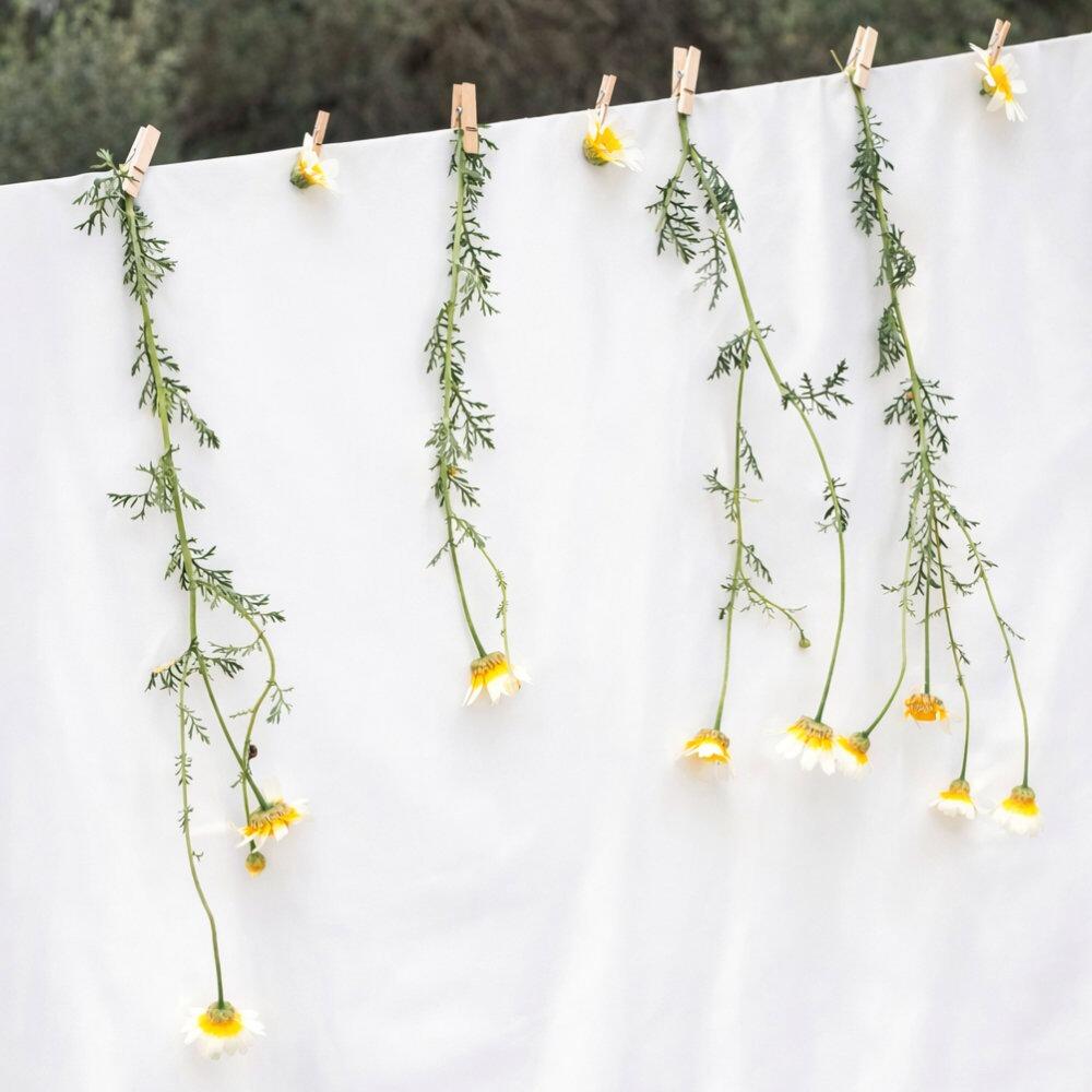 White cotton cambric fabric pegged to a washing line with flowers