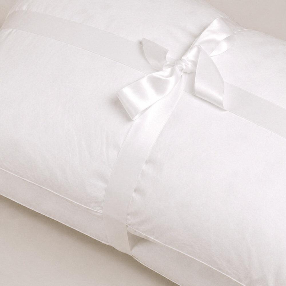 Close-up of white pillows tied with ribbon