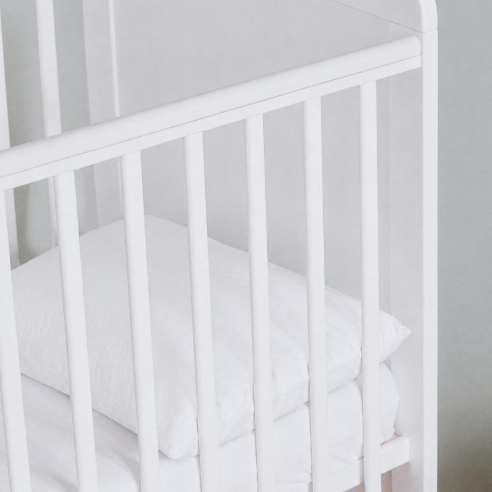 Close-up of a white cot pillow in a cot