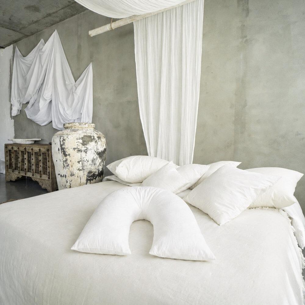 Wool v-shaped pillow styled on a bed