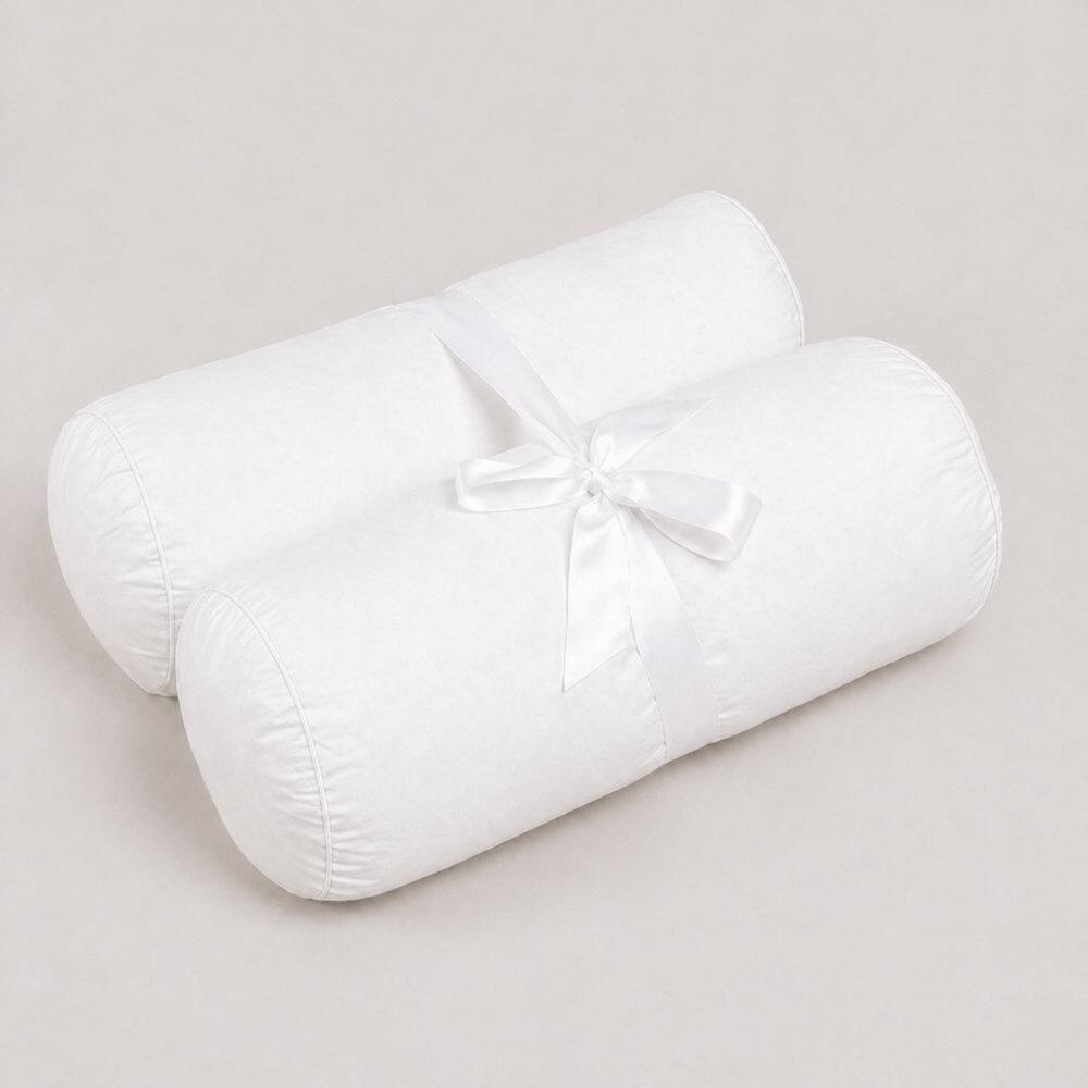 Pair of white cot bolster pillows tied with ribbon