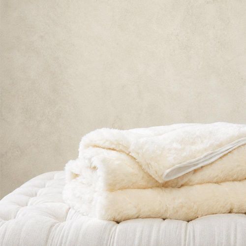 Wool mattress topper folded on buttoned cushion