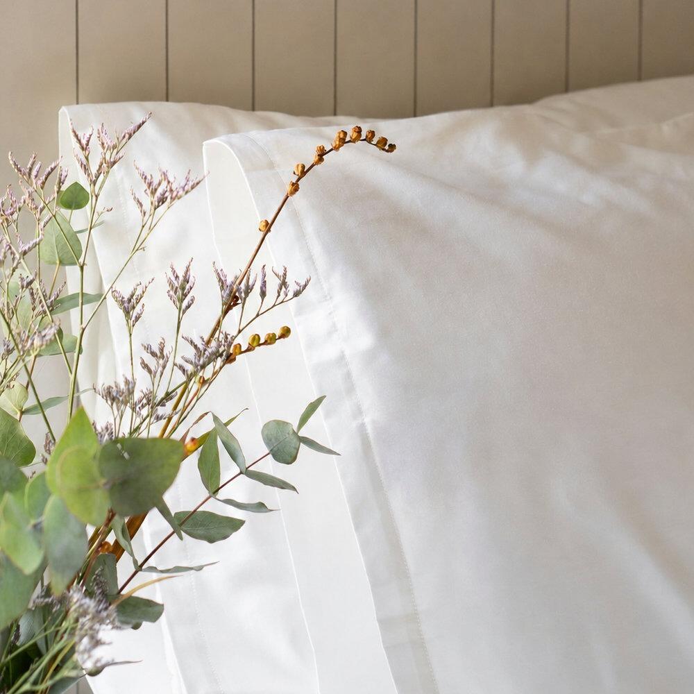 Close-up of a white super king pillowcase with natural floral details